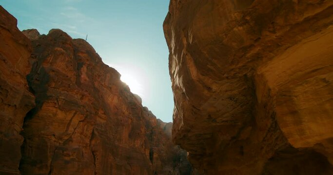 Most popular tourist attraction in Jordan - Petra temple Treasury Al-Khazneh carved out of sandstone rock face in Nabatean city inhabited by Arabs in ancient times. 4K reveal shot with sun flare