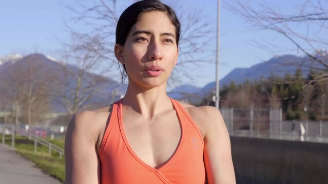 Closeup, Stunning hispanic woman stretching arms in orange top