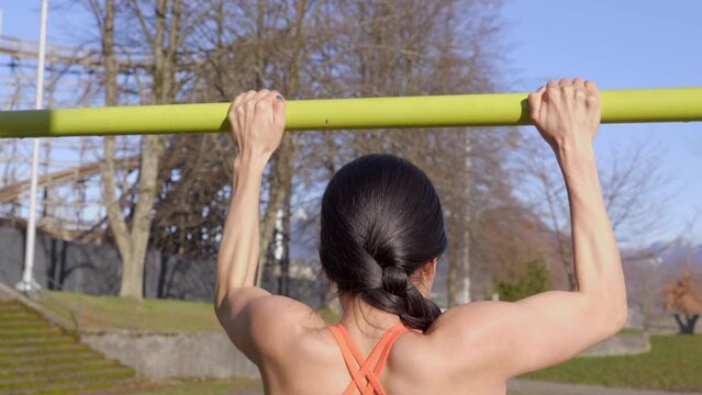 Behind View of Sporty Woman Doing Pullups, Closeup