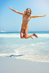Summer celebrations. Shot of a beautiful young woman at the beach.