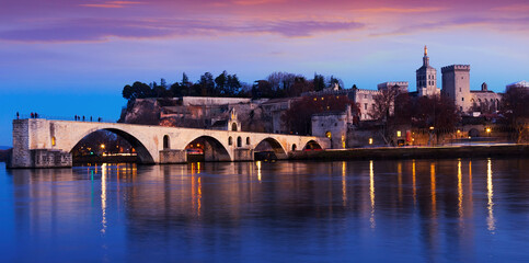 Obraz premium View of four surviving arches of Pont St-Benezet and Avignon Cathedral at sunset, France