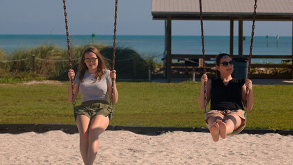 Two young women on a swing have fun