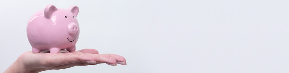 3d pink piggy bank in the beautiful hands of a girl..Close-up photo on a white background.