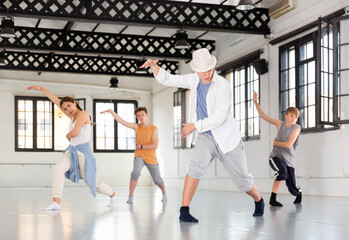 Fototapeta premium Team of young dancers training street dance moves and having fun