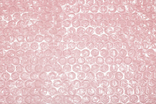 polymer packaging material, layers of smooth and bubble polyethylene, bubble wrap on a pink background