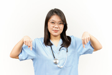 Showing Product and Pointing Down Of Asian Young Doctor Isolated On White Background