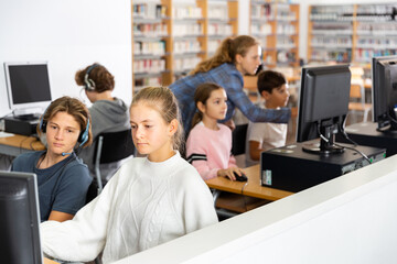 Fototapeta na wymiar Pupils using computers at lesson, teacher teaching them in classroom