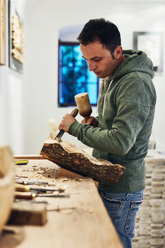 Whittling is his favorite thing to do. Cropped shot of an artist carving something out of wood.