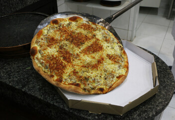 Pizza pronta sendo embalada para entrega delivery