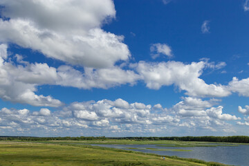 Fototapeta na wymiar Nature summer landscape with tributary of Irtysh river and bright blue sky with clouds. Natural background and beautiful place