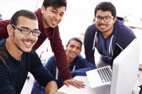 Workshopping an idea. Cropped shot of young students gathered around a computer.