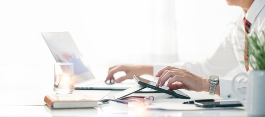 Businessman working on tablet and laptop computer at desk, planning analyze investment and marketing, new business project finance investment concept.