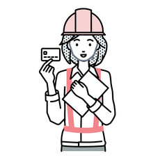 立って書類とカードを手に持つ工事現場の女性