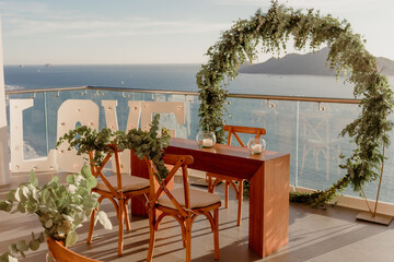 Wedding bride and groom table with floral decoration behind. Love sign and horizon view to the ocean
