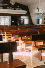 Benches in an empty catholic church, sunlight entering from the side