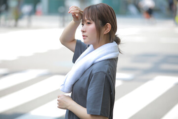 タオルで汗を拭く女性