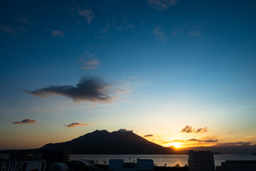 Fototapeta na wymiar 桜島から昇る朝日が錦江湾、街を照らし始める