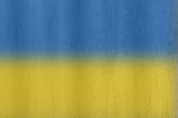 Ukrainian flag on a textured background. The flag of Ukraine on the old grunge wall in the background, the concept of destruction and war in Ukraine.Support for Ukrainians in the war with Russia