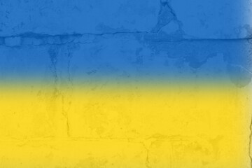 Ukrainian flag on a textured background. The flag of Ukraine on the old grunge wall in the background, the concept of destruction and war in Ukraine.Support for Ukrainians in the war with Russia