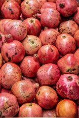 Pomegranates are for sale at a fruit and vegetable market stall
