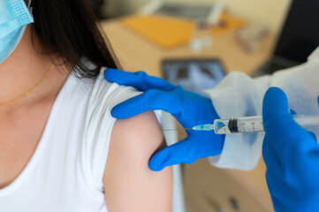 Female doctor holds syringe and bottle with vaccine for coronavirus cure. Concept of corona virus treatment, injection, shot and clinical trial during pandemic.OMICRON
