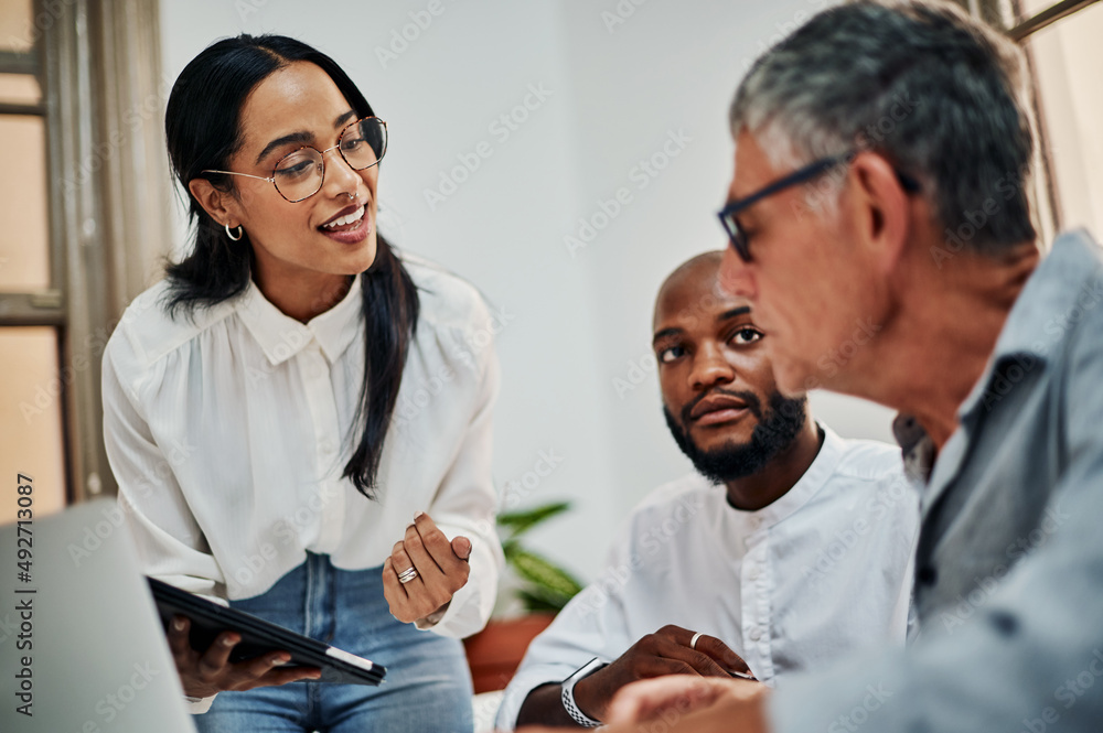 Poster Teamwork gets it done quickly and efficiently. Shot of a group of businesspeople using a digital tablet during a meeting in a modern office.