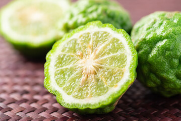 Organic Kaffir lime, Citrus fruit used in Southeast Asian cuisine and essential oil - obrazy, fototapety, plakaty