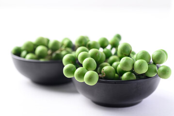 Pea eggplant or Turkey berry (Solanum torvum) on white background, Edible green fruits in Thai food curry or chili pastes
