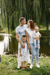 Happy family resting in park near the lake