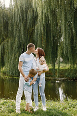 Happy family resting in park near the lake