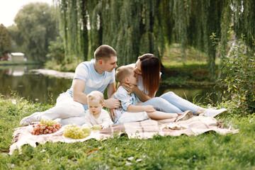 Happy family have a picnic in park near the lake