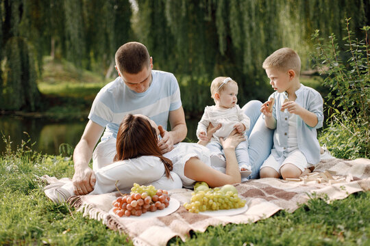 Happy Family Have A Picnic In Park Near The Lake