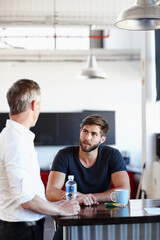 Business during their break. Shot of two handsome businessmen having a discussion in the office.