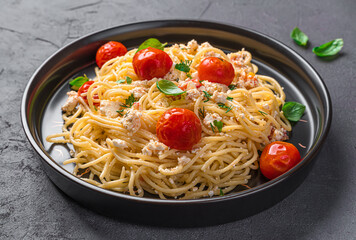 Fetapasta, spaghetti with feta cheese, cherry tomatoes and herbs close-up.