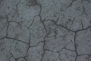 Texture of the dried earth. Dark gray background with cracks and hollows. Drought and lack of...