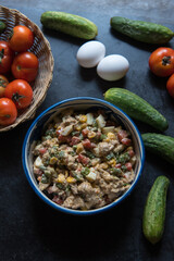 Popular continental food cheese vegetable augratin served in a bowl on a dark background. Top view.