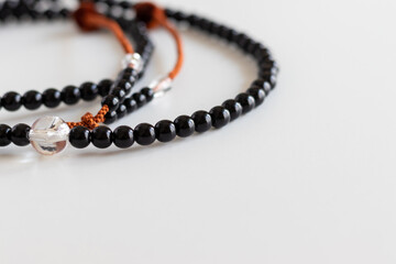 白い机の上に黒い数珠