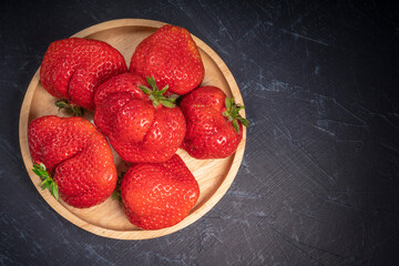 Red strawberries on wooden bowl in wooden background, Fresh Amaoh Strawberry  on wooden plate background.