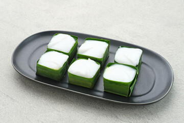 Kue talam or Talam cake made from combination of rice flour, sugar, and coconut milk. Served on plate on grey background.
