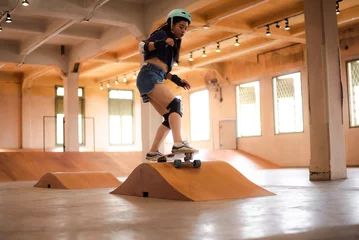 Foto op Plexiglas skater woman person playing skateboard in sport gym, young Asian woman are happy and fun with skateboarding lifestyle in city, teenage hipster female trendy fashion © chokniti