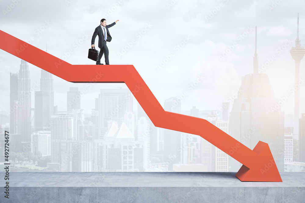 Poster business man standing and balancing on abstract red downward chart arrow on light city background wi