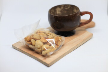 Brown wooden cup on a wooden tray with snacks