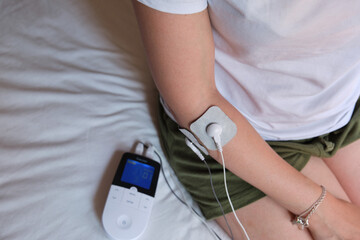 electrostimulation treatment, electrodes on the elbow, tens or ems treatment to reduce inflammation and improve blood circulation. rehabilitation. epicondylitis