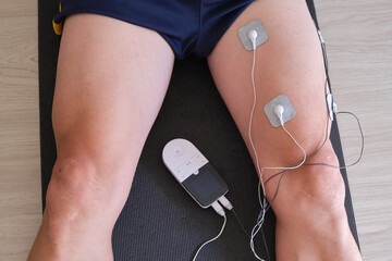 electrostimulation treatment, electrodes on a man's leg, tens treatment, ems or massages to improve muscle health and blood circulation. rehabilitation