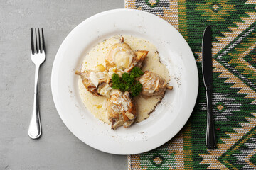 Chicken stewed in a creamy sauce on white plate