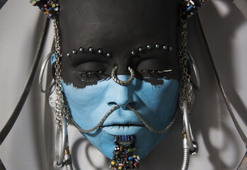 Indigenous face sculpture. Close-up of statue, portrait of person with African features. Artwork with incorporation of recycled materials.