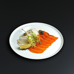 traditional dishes of European cuisine, delicacy, banquet snack. culinary dishes on a white plate on a black background. restaurant service