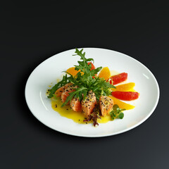 traditional dishes of European cuisine, delicacy, banquet snack. culinary dishes on a white plate on a black background. restaurant service