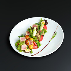 traditional dishes of European cuisine, delicacy, banquet snack. culinary dishes on a white plate on a black background. restaurant service