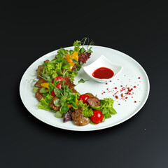 traditional dishes of European cuisine, delicacy, banquet snack. culinary dishes on a white plate on a black background. restaurant service
